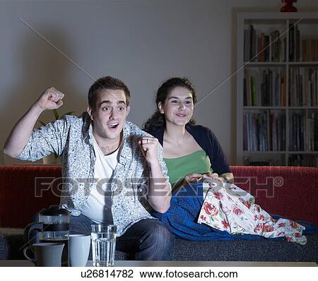Excited couple watching television View Large Photo Image Stock Image - Excited couple watching television. Fotosearch