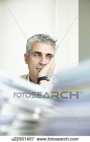 Stock Photo - Exhausted man with paperwork. Fotosearch