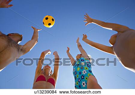 Picture - Family playing ball at the beach. Fotosearch