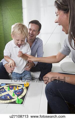 Stock Image - Family playing board game. Fotosearch