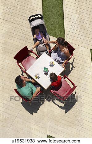 Stock Photo - Family seated around table. Fotosearch
