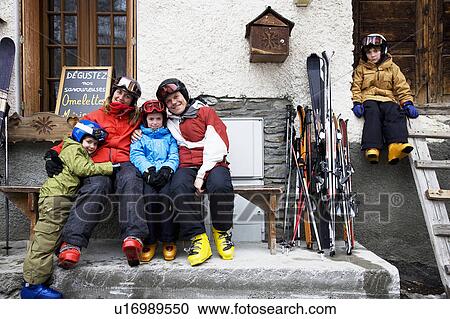 Family sitting outside barn with skis View Large Photo Image Stock Image - Family sitting outside barn with skis. Fotosearch