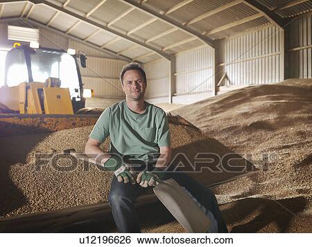 Stock Photograph - Farmer in grain store. Fotosearch