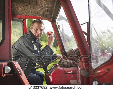 Farmer in tractor eating apple View Large Photo Image Stock Image - Farmer in tractor eating apple. Fotosearch