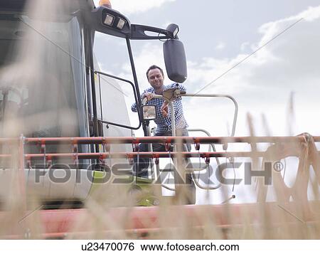 Stock Photograph - Farmer on combine harvester. Fotosearch