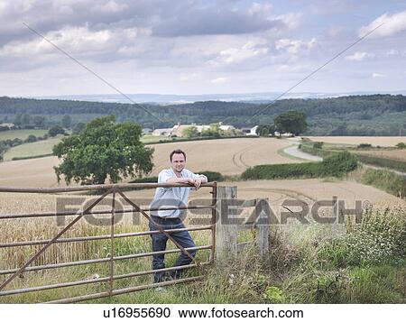 Farmer with crops and farm View Large Photo Image Stock Image - Farmer with crops and farm. Fotosearch