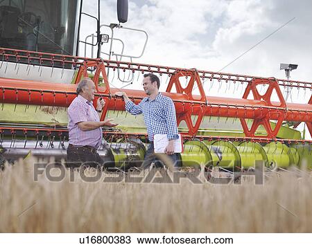 Farmers in front of combine harvester View Large Photo Image Stock Image - Farmers in front of combine harvester. Fotosearch