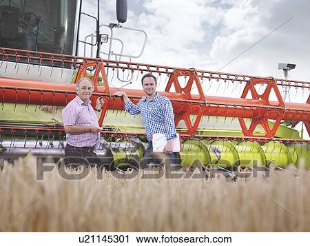 Farmers in front of combine harvester View Large Photo Image Stock Image - Farmers in front of combine harvester. Fotosearch