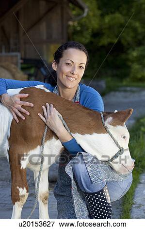 Farmwoman hugging calf View Large Photo Image Stock Photo - Farmwoman hugging calf. Fotosearch