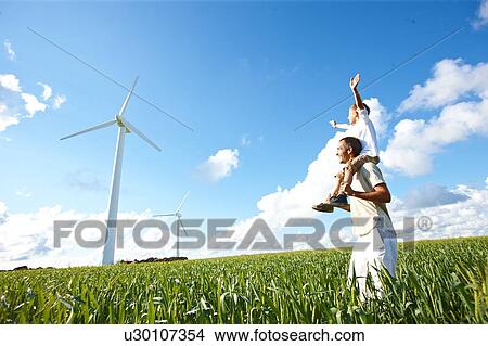 Picture - Farther and son looking at wind turbine. Fotosearch
