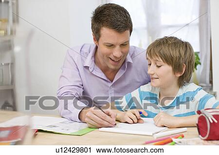 Stock Image - Father and son doing homework. Fotosearch