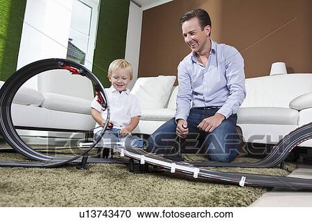 Father and son playing with race track View Large Photo Image Stock Image - Father and son playing with race track. Fotosearch
