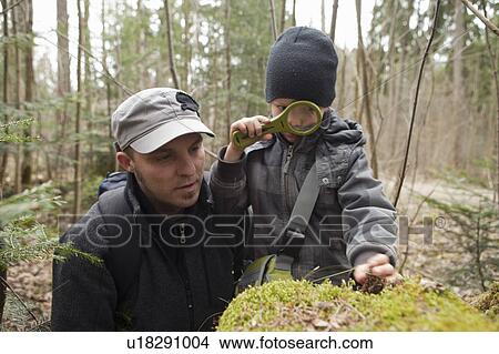 Picture - Father and son using loupe. Fotosearch