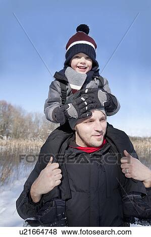 Stock Photo - Father carrying his son shoulder high. Fotosearch