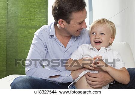 Picture - Father hugging son. Fotosearch