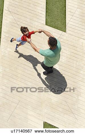 Father swinging son around View Large Photo Image Stock Photo - Father swinging son around. Fotosearch