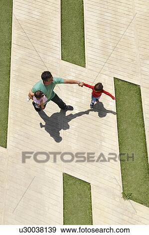 Stock Photo - Father with two children in city square. Fotosearch