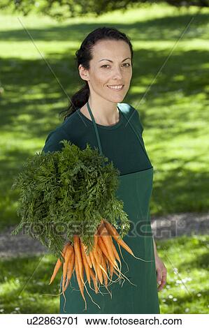 Female gardener with bunch of carrots View Large Photo Image Stock Image - Female gardener with bunch of carrots. Fotosearch