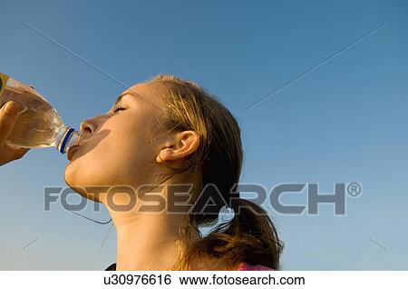 Stock Photograph - Female hiker drinks water. Fotosearch