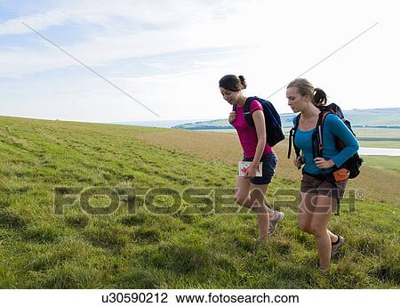 Female hikers climb hill View Large Photo Image Stock Image - Female hikers climb hill. Fotosearch