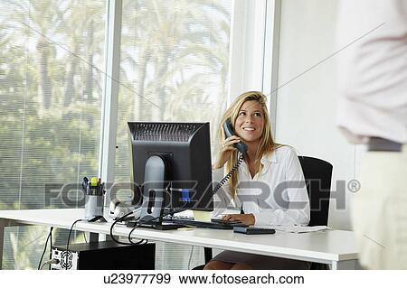 Female office worker on the phone View Large Photo Image Stock Photo - Female office worker on the phone. Fotosearch