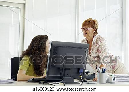 Stock Photograph - Female office workers chatting. Fotosearch