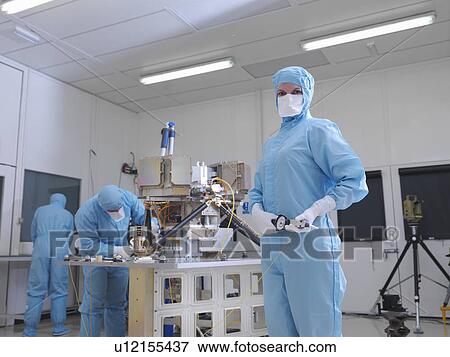 Stock Photo - Female worker building satellite dish. Fotosearch