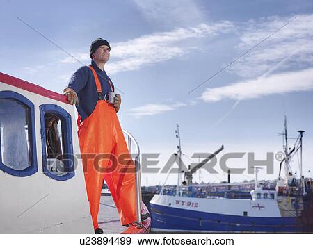 Stock Photo - Fisherman drinking tea on boat. Fotosearch