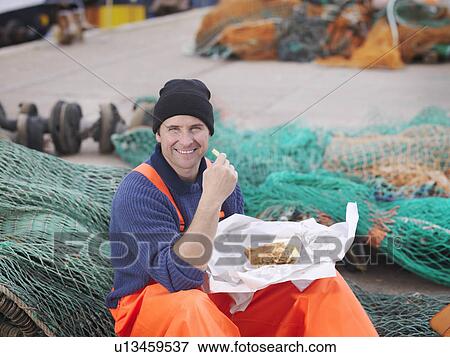 Stock Photo - Fisherman eating fish and chips. Fotosearch