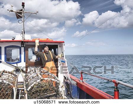 Fisherman looks out to sea on boat View Large Photo Image Stock Image - Fisherman looks out to sea on boat. Fotosearch