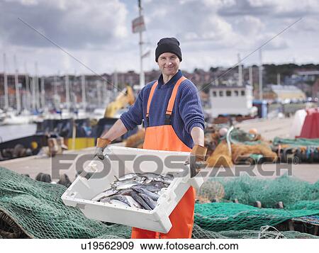 Fisherman with box of fish in harbour View Large Photo Image Stock Photo - Fisherman with box of fish in harbour. Fotosearch