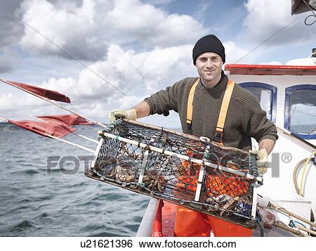 Stock Photograph - Fisherman with lobster pot and crabs. Fotosearch
