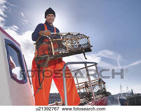 Stock Photo - Fisherman with lobster pot on boat. Fotosearch