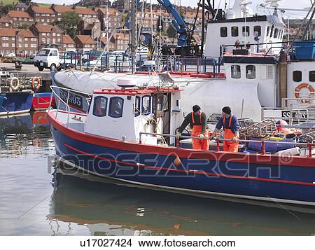 Picture - Fishermen on boat in harbour. Fotosearch