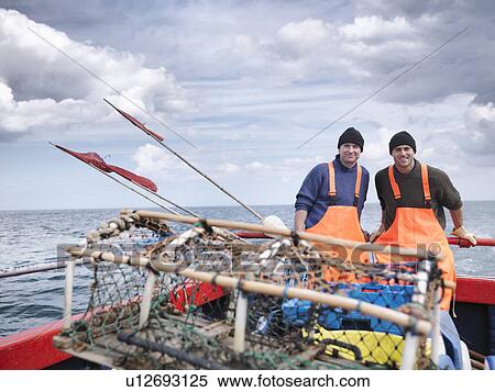 Stock Photography - Fishermen on boat with lobster pot. Fotosearch