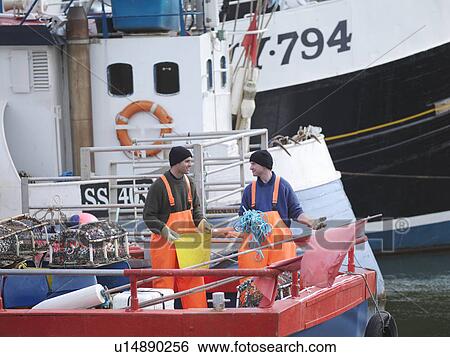 Stock Photograph - Fishermen on fishing boat in harbour. Fotosearch