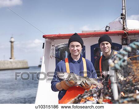 Stock Photograph - Fishermen on fishing boat with fish. Fotosearch