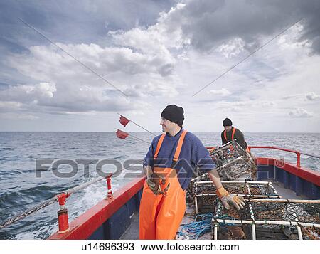 Stock Image - Fishermen with crab and lobster pots. Fotosearch