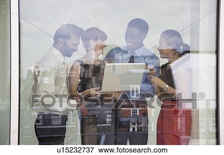 Stock Photo - Four business people using laptop. Fotosearch