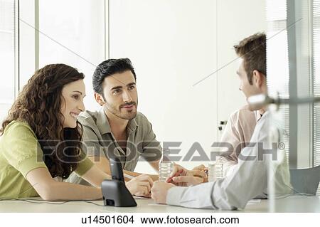 Picture - Four people in a meeting. Fotosearch