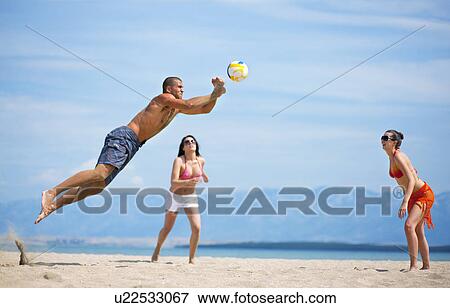 Friends playing volleyball at the beach View Large Photo Image Stock Photo - Friends playing volleyball at the beach. Fotosearch