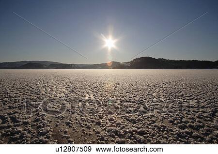 Frozen lake, sun low on horizon View Large Photo Image Stock Photo - Frozen lake, sun low on horizon. Fotosearch