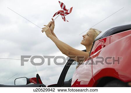 Girl holding windmill in an electric car View Large Photo Image Stock Image - Girl holding windmill in an electric car. Fotosearch