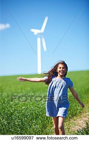 Girl in field with wind turbine View Large Photo Image Stock Photo - Girl in field with wind turbine. Fotosearch