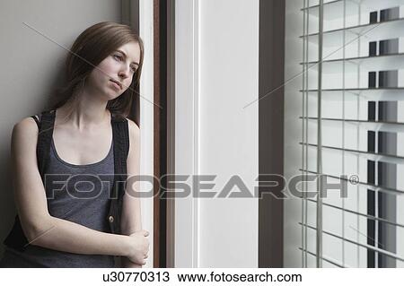 Stock Image - Girl leaning against wall. Fotosearch