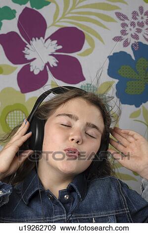 Girl listening on headphones singing View Large Photo Image Stock Photo - Girl listening on headphones singing. Fotosearch