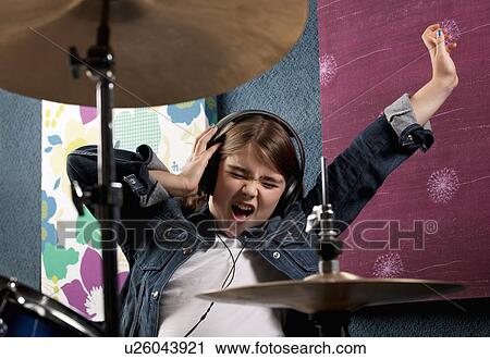 Stock Image - Girl listening to headphone with drums. Fotosearch