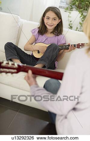 Girl playing the guitar View Large Photo Image Stock Photograph - Girl playing the guitar. Fotosearch