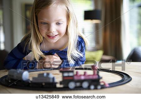 Girl playing with toy train View Large Photo Image Stock Photo - Girl playing with toy train. Fotosearch
