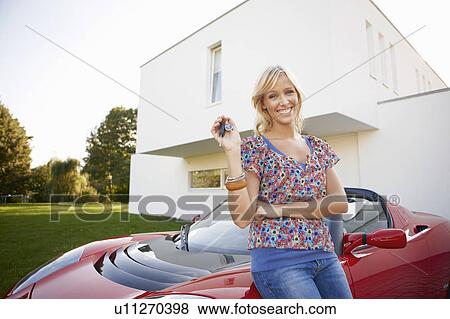 Girl proudly showing her key to a car View Large Photo Image Stock Photo - Girl proudly showing her key to a car. Fotosearch